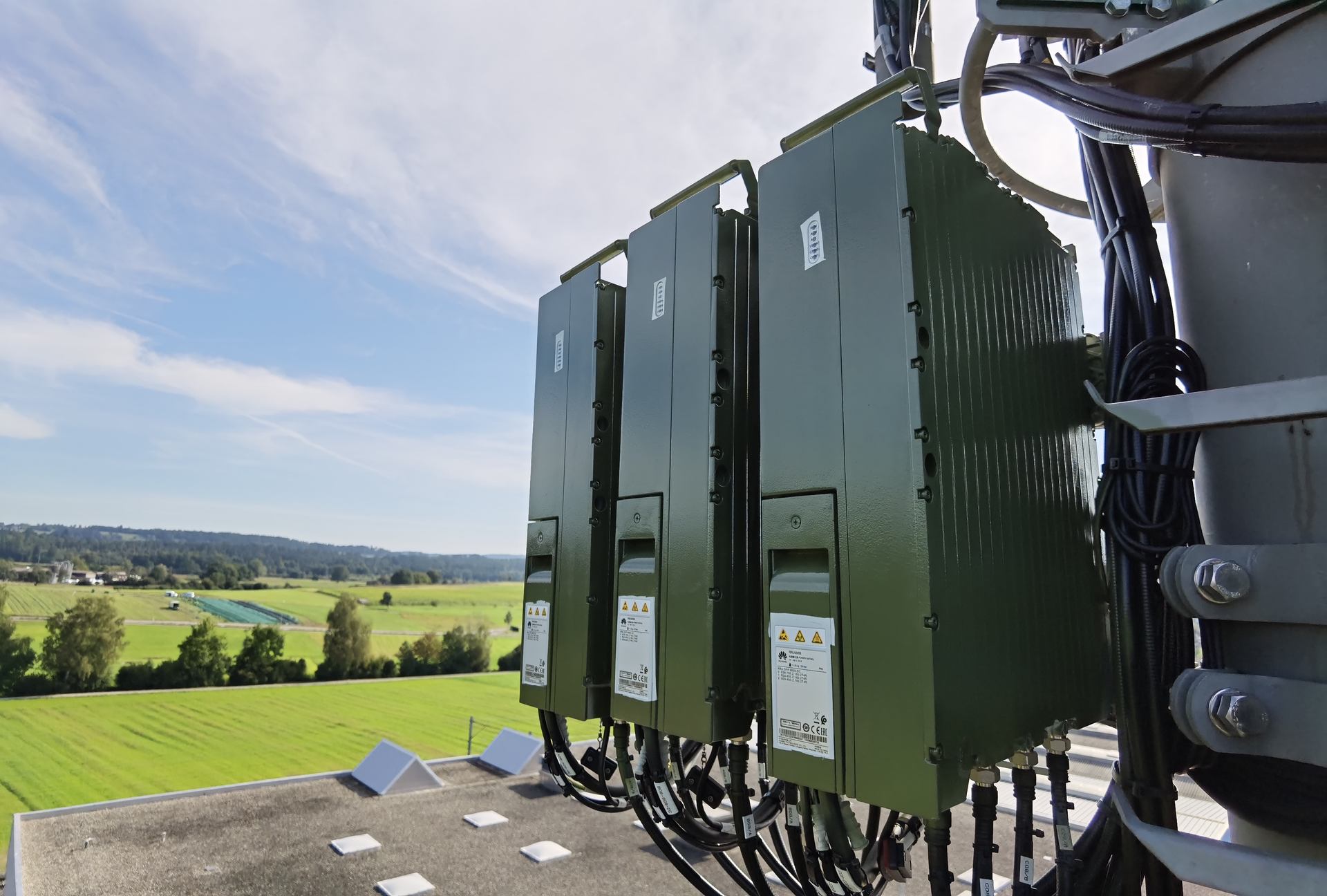Radio units on a mast overlooking fields.