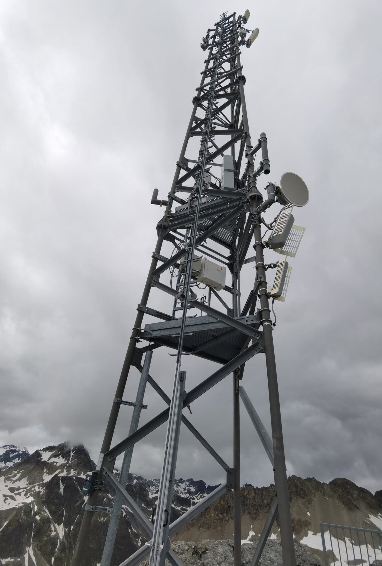 A lattice communications tower against a cloudy sky.