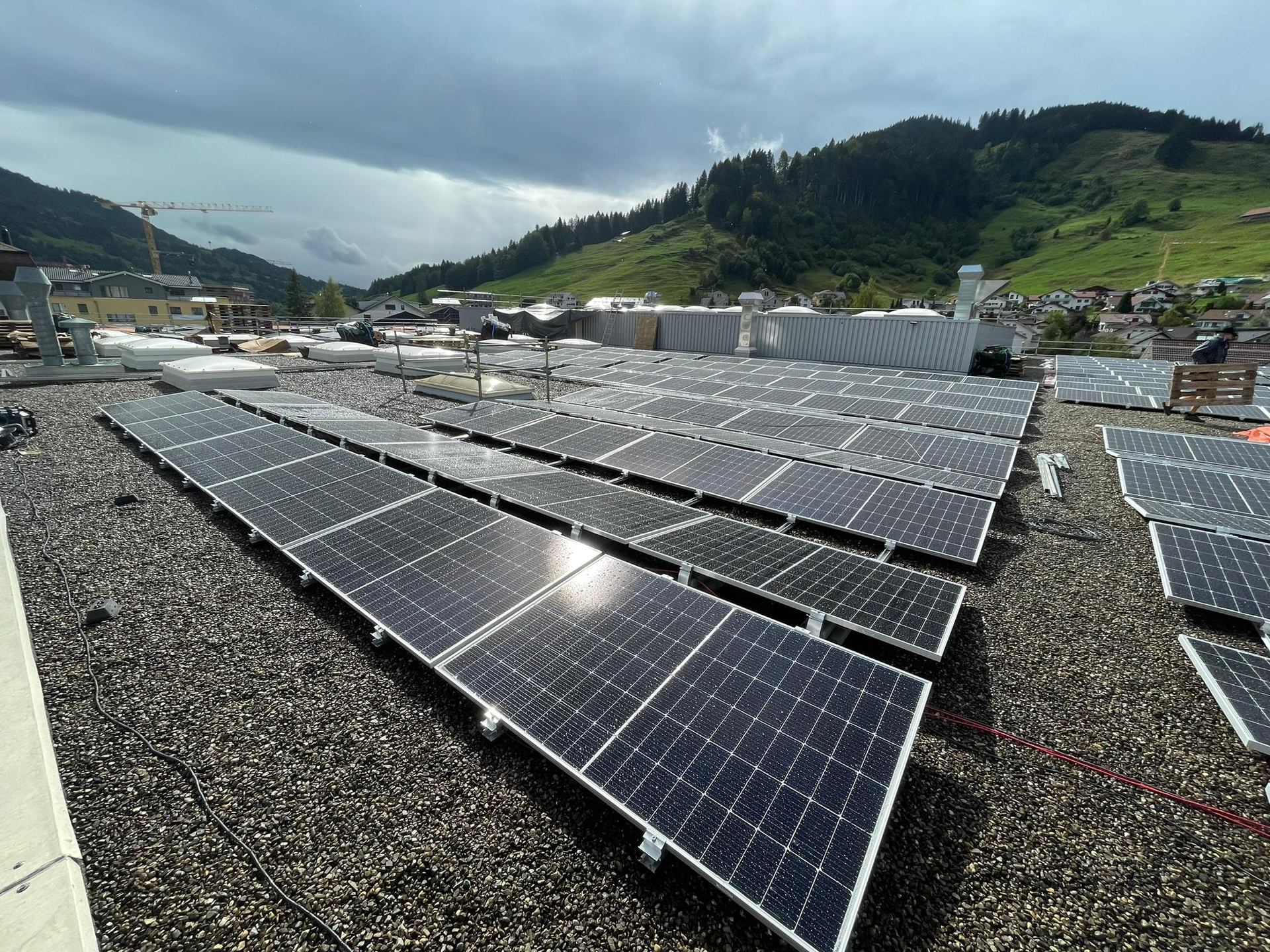 Rows of photovoltaic modules on a flat rooftop.