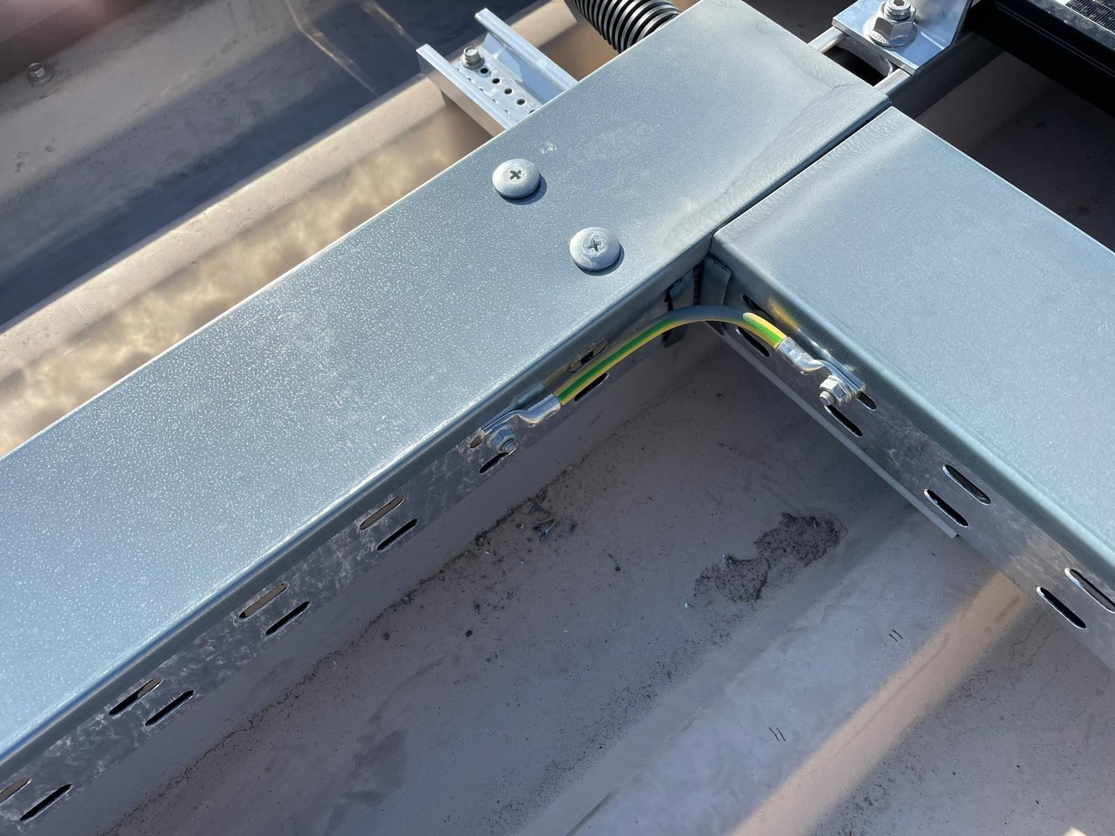 A close-up of a metal solar mounting bracket and fasteners.